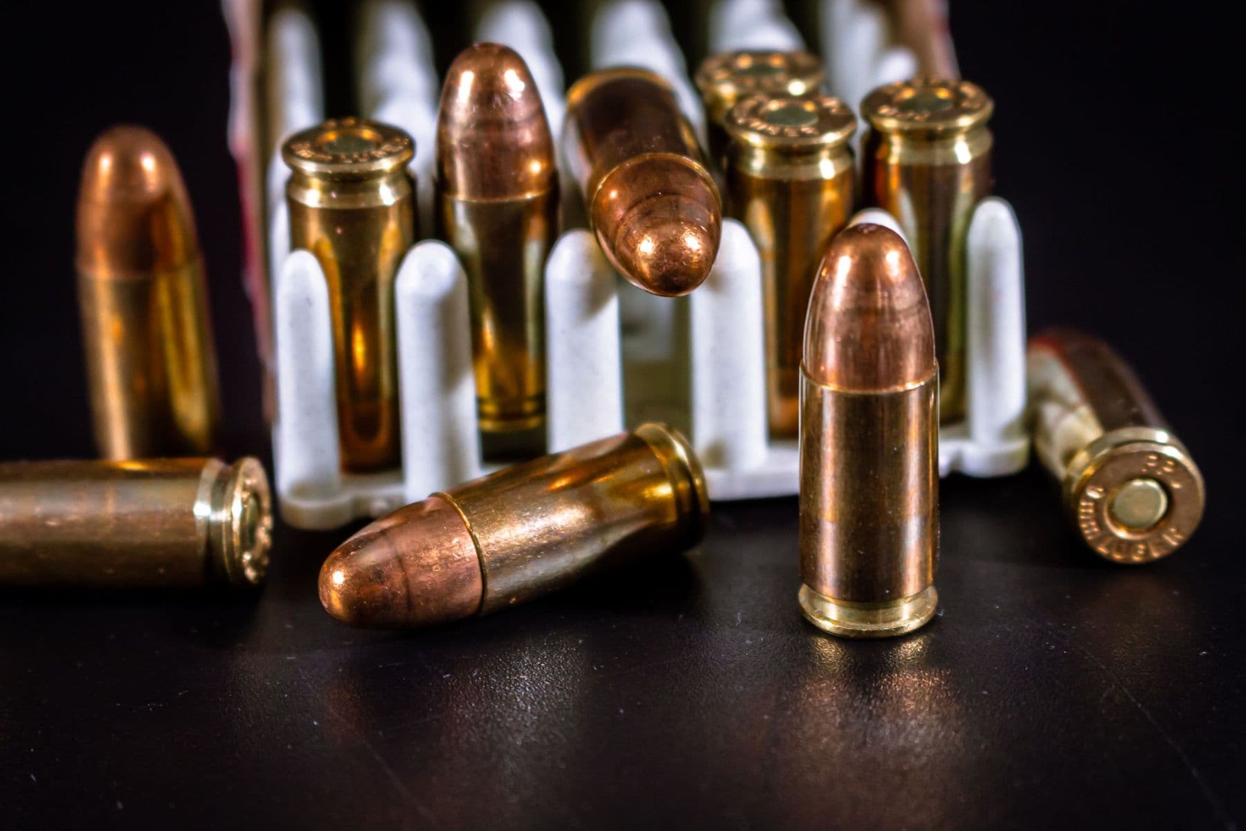 9mm cartridges standing upright in front of an open ammunition box