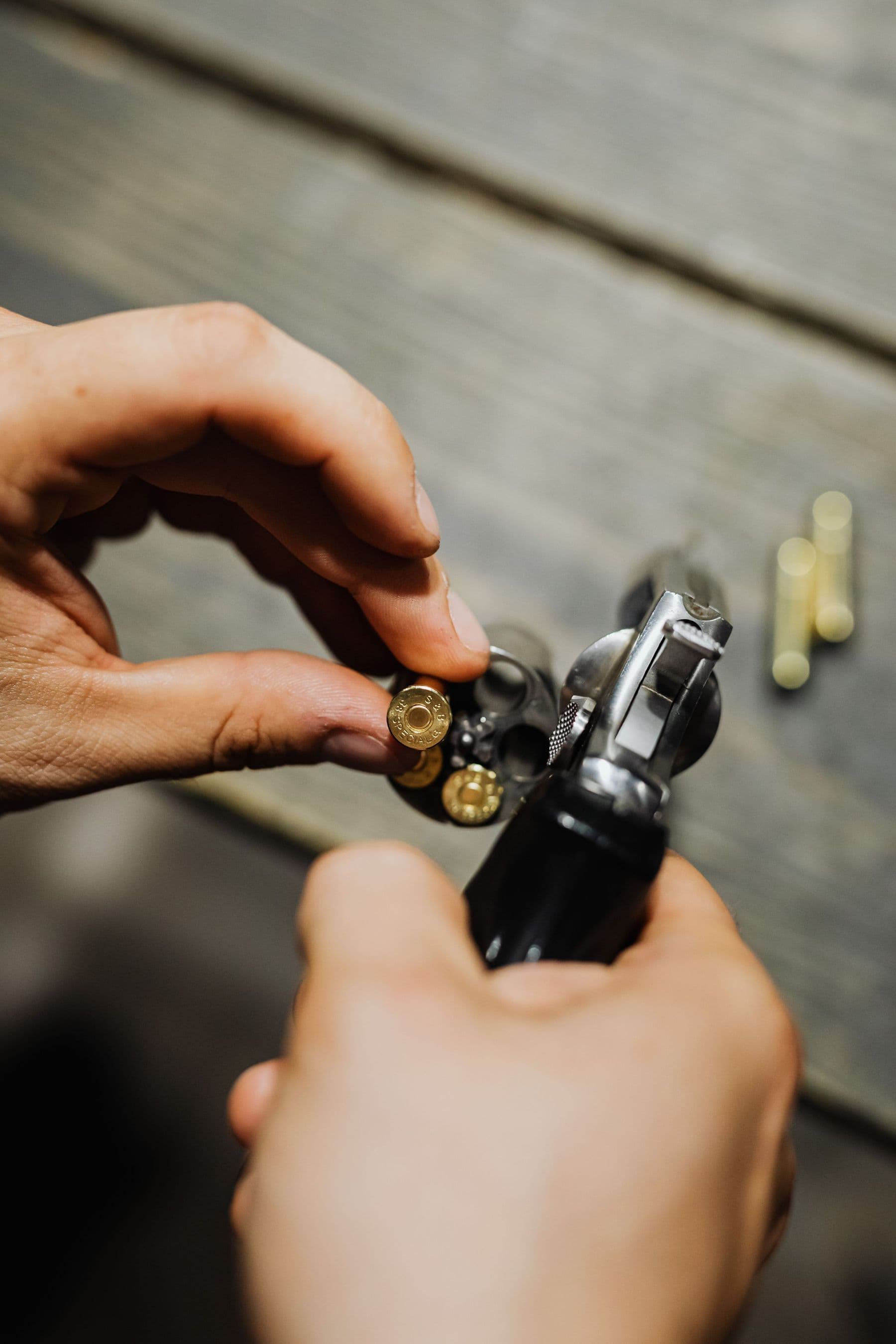 Hands loading cartridges into a revolver cylinder