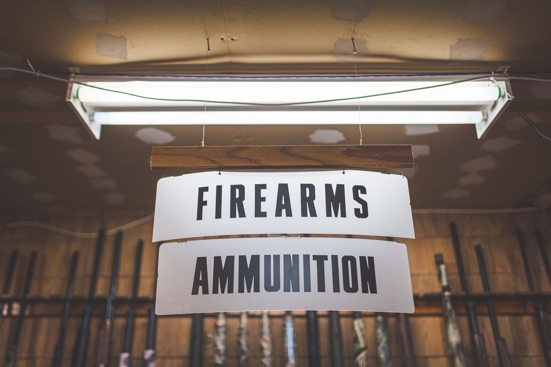 A hanging Firearms & Ammunition sign inside a gun shop