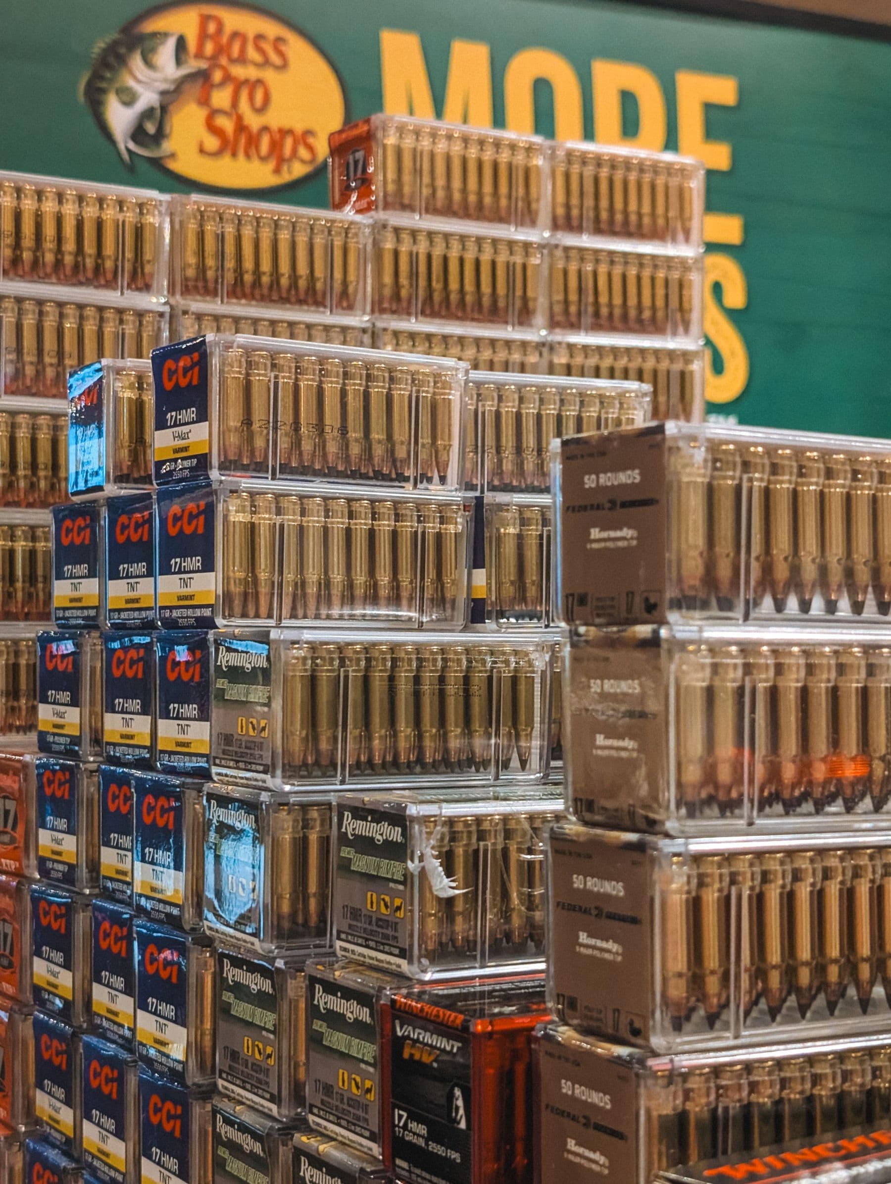 Boxes of ammunition stacked on retail shelving under a store sign