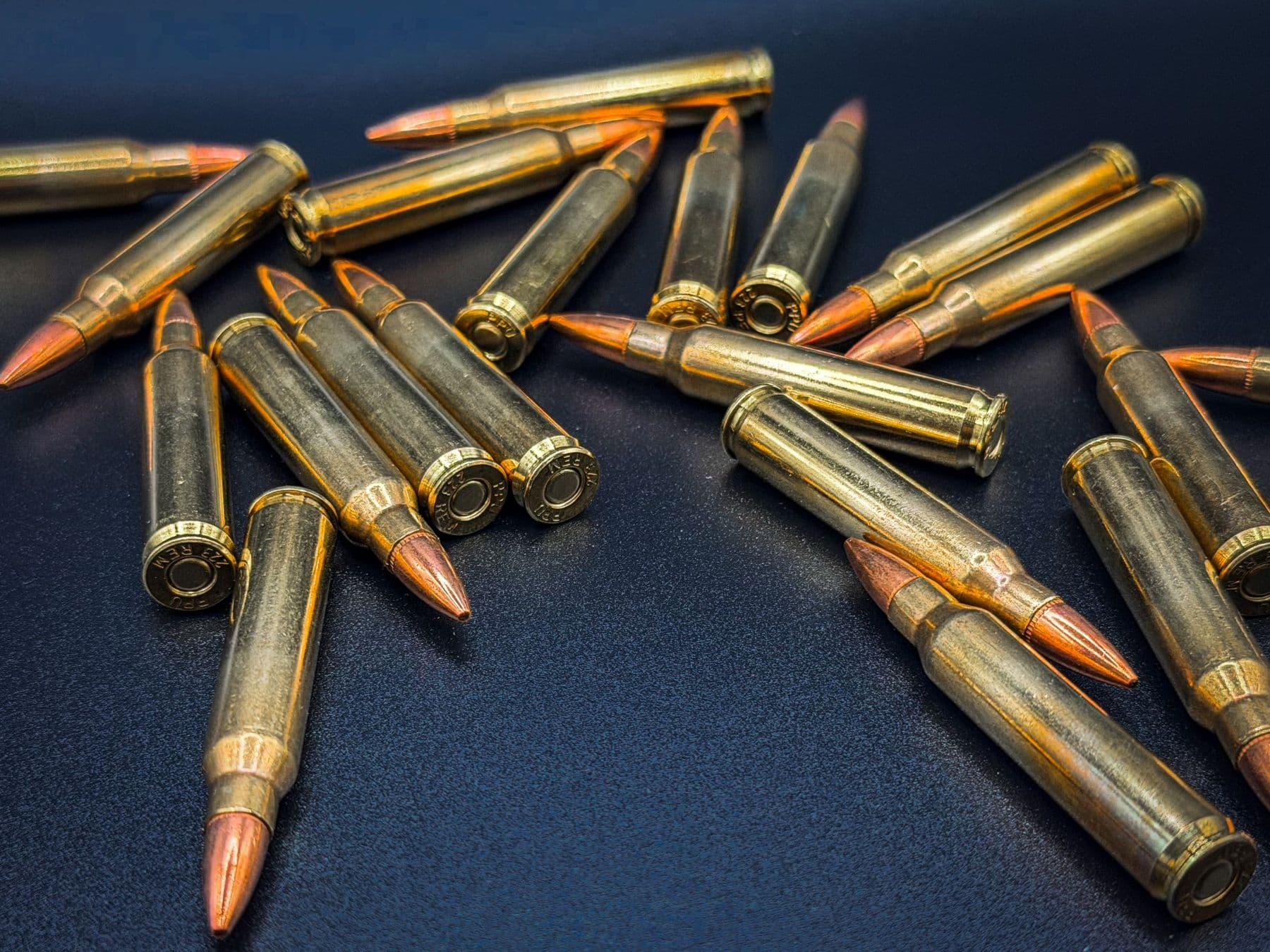 .223 cartridges scattered across a dark blue surface