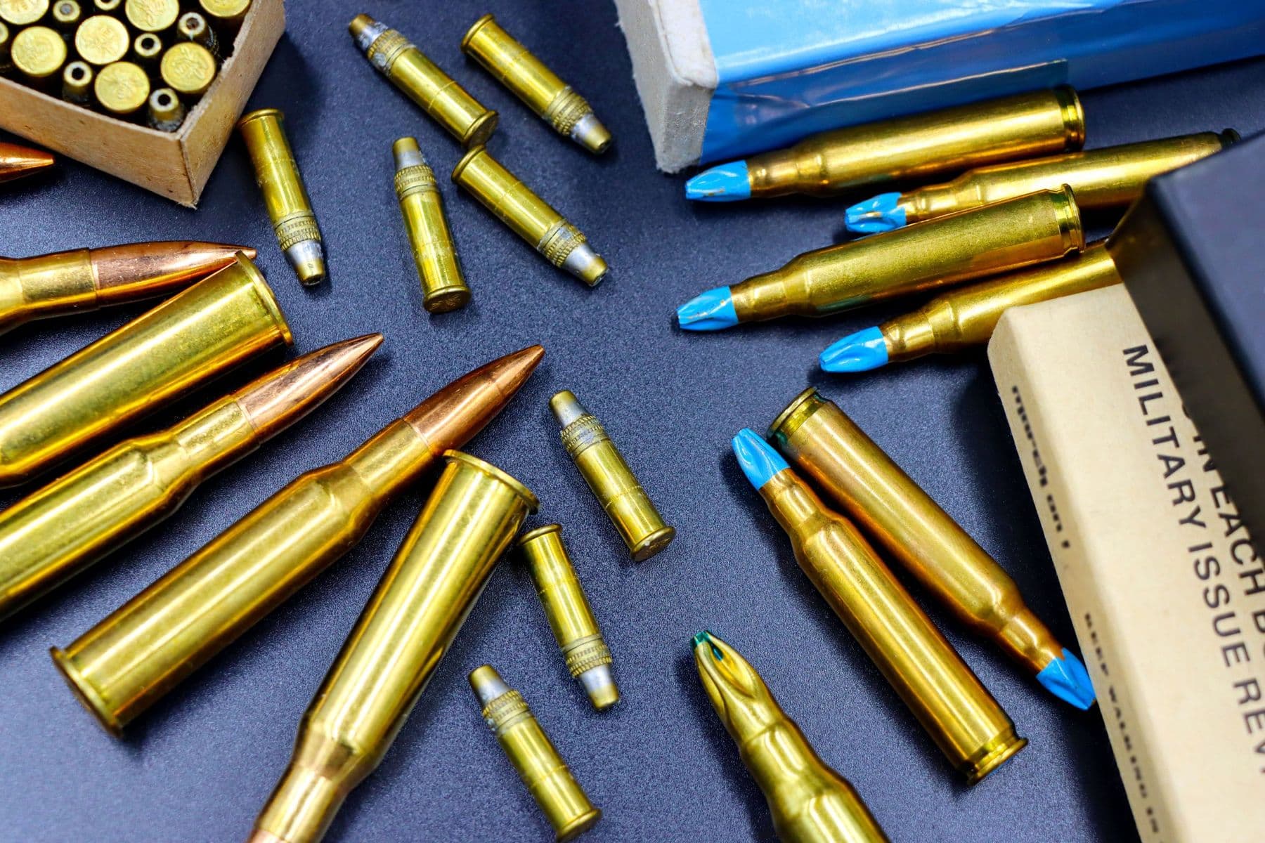 Rifle and pistol cartridges of several calibres laid out on a dark surface
